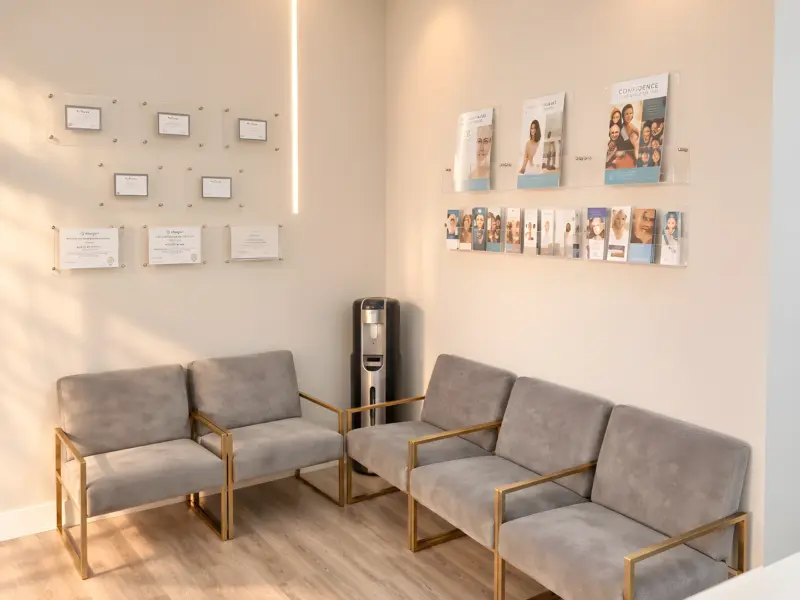 Waiting lounge at the Lincoln Park med spa with velvet chairs and framed certificates